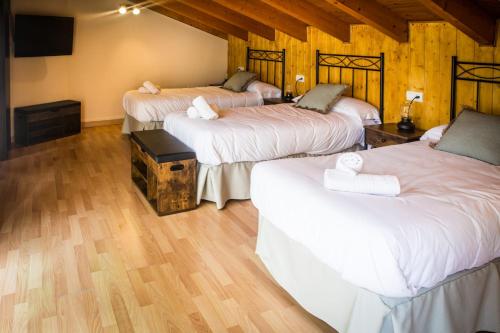 3 camas en una habitación con suelo de madera en Ciudad de Teruel, en Teruel