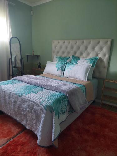 sypialnia z dużym łóżkiem z niebieską i białą pościelą w obiekcie Diamonds on 2 Patricia Place w mieście King Williamʼs Town