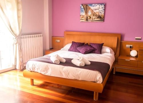 a bedroom with a large bed with purple walls at Ciudad de Teruel in Teruel