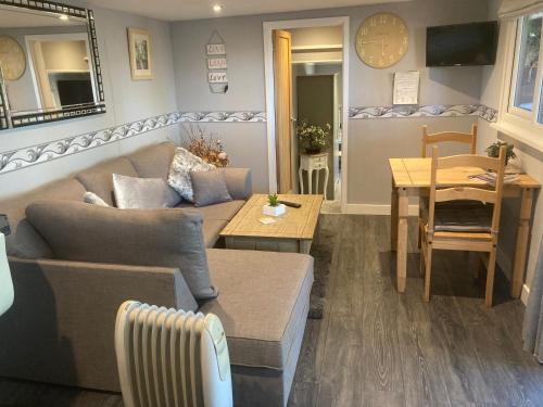 a living room with a couch and a table at The Spinney lodge in Bubbenhall