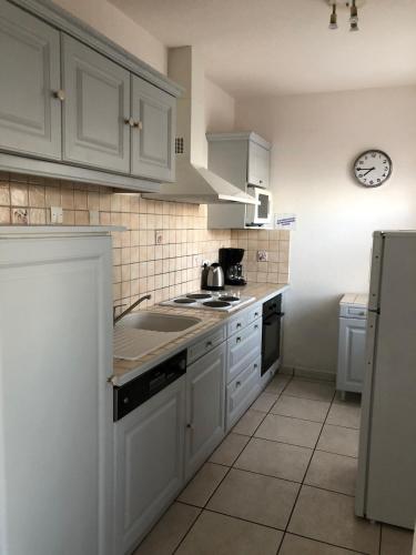 une cuisine avec des armoires blanches et un four à plaques de cuisson dans l'établissement FRONT DE MER - T3 LEUCATE PLAGE, à Leucate