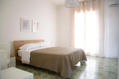ein weißes Schlafzimmer mit einem Bett und einem großen Fenster in der Unterkunft Donna Agata House in Catania