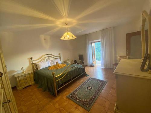 Un dormitorio con una cama verde y una lámpara de araña. en Casa vacanze il pettirosso. en Pisogne