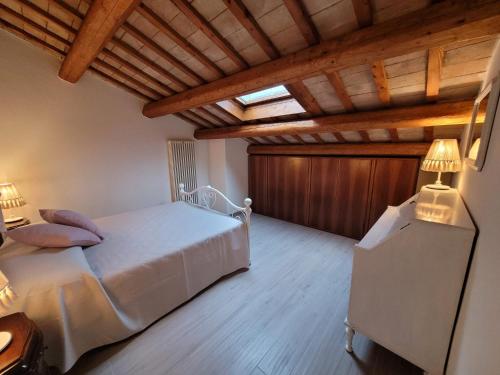 1 dormitorio con cama blanca y techo de madera en Attic en Rímini