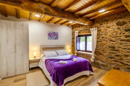 sypialnia z łóżkiem i kamienną ścianą w obiekcie Casa Añolo w mieście Sober