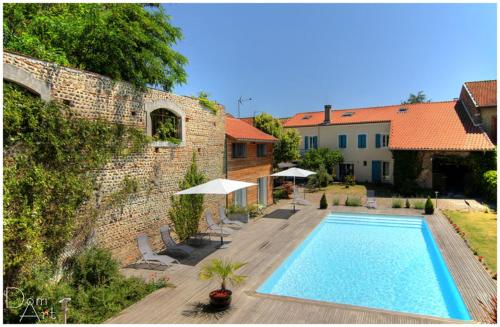 - une piscine en face d'un bâtiment en briques dans l'établissement Chambre d'Hôtes La Cour des Saligues, à Riscle