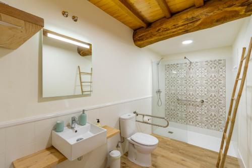 W łazience znajduje się umywalka, toaleta i lustro. w obiekcie Casa Añolo w mieście Sober