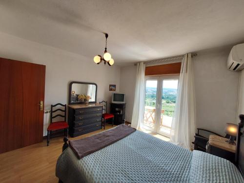 Schlafzimmer mit einem Bett, einem Spiegel und einem Fenster in der Unterkunft Casa Machado in Vila Real