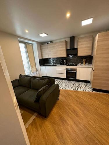 un salon avec un canapé et une cuisine dans l'établissement Apt Moderne 2 chambres 5 voyageurs Paris, à Paris