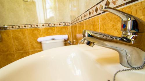 a bathroom with a sink with a faucet at San José Guest House in Granada