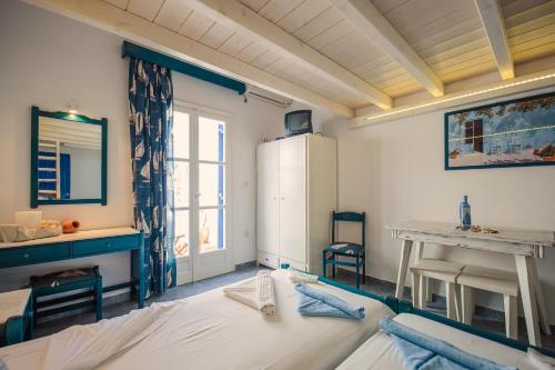 a room with a bed and a table and a refrigerator at Villa Anna Maria in Aliki