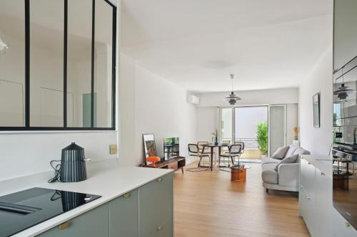 une cuisine et un salon avec des murs blancs et du parquet dans l'établissement Designer flat, luxurious, close from Palais, terrasse, private garage, Air Conditoning, à Cannes