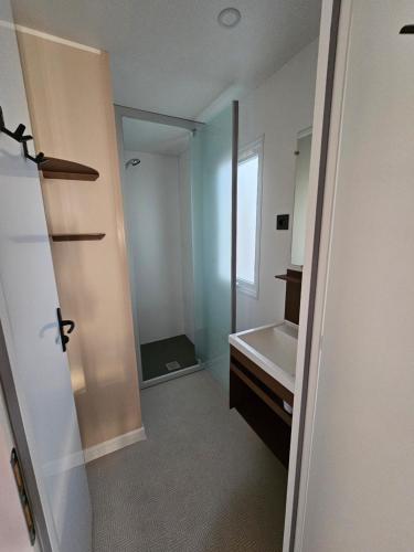 a bathroom with a tub and a sink and a mirror at Camping Le Dolium in Laudun