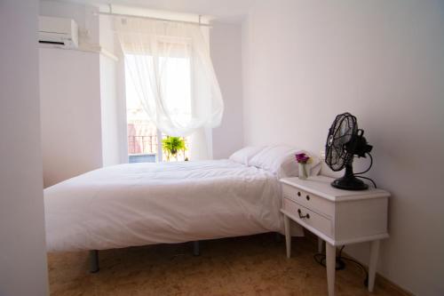 a bedroom with a white bed and a window at San José Guest House in Granada