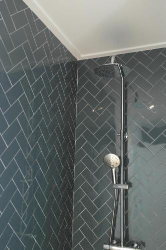 a bathroom with a blue tiled wall with a shower at Gozo - new luxury villa with private pool in Foz do Arelho