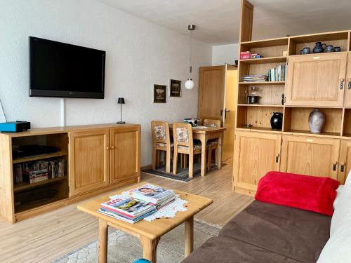 ein Wohnzimmer mit einem TV und einem Tisch in der Unterkunft Apartment Heidi in Bad Goisern