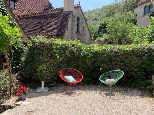 - deux chaises assises devant une haie dans l'établissement La Lotoise gîte au Coeur De Saint-Cirq-Lapopie, à Saint-Cirq-Lapopie