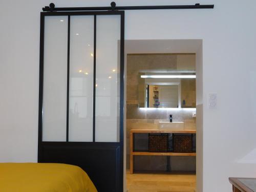 een kamer met een bed en een badkamer met een wastafel bij Studio Calme Hyper Centre Brive in Brive-la-Gaillarde