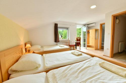 a bedroom with three beds and a window at House Krizmanić in Grabovac