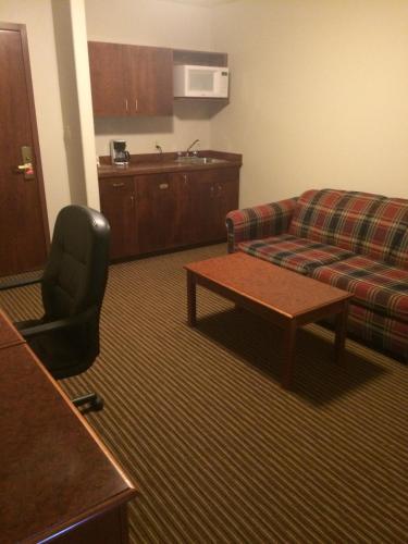 a living room with a couch and a table at Foxwood Inn and Suites in Fox Creek