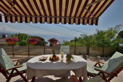 a table with a bowl of fruit on a patio at Apartment RELAX Opatija in Opatija