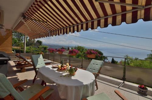 a patio with a table and chairs and an umbrella at Apartment RELAX Opatija in Opatija