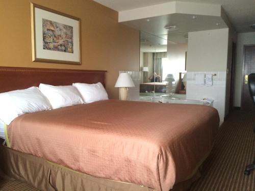 a hotel room with a large bed and a bathroom at Foxwood Inn and Suites in Fox Creek