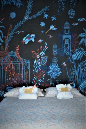 two beds in front of a wall with a mural at Au temps suspendu in Champagney