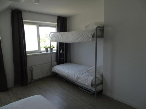 a bunk bed in a room with a window at Guesthouse Wormer in Wormer