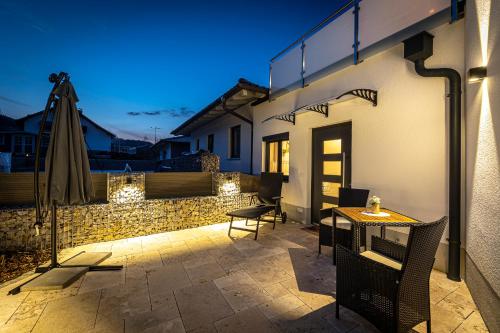 a patio with a table and chairs and an umbrella at Riedbach-Lodge 2 in Viechtach