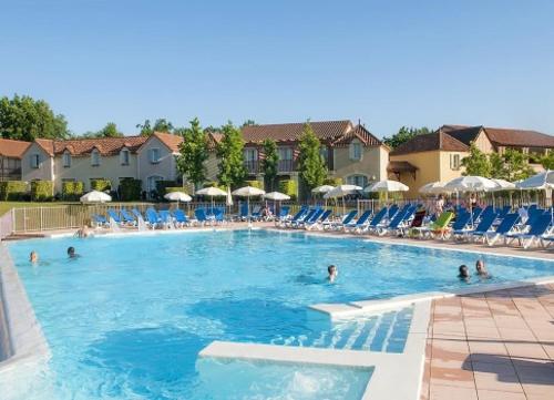 a swimming pool at a resort with people in it at Évasion de Rêve nature ,piscine et lac de pêche in Monflanquin