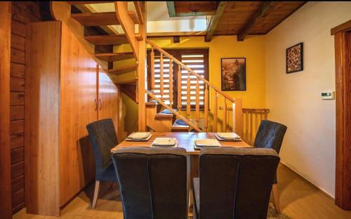 uma sala de jantar com uma mesa e cadeiras e uma escadaria em Chatka M3 
