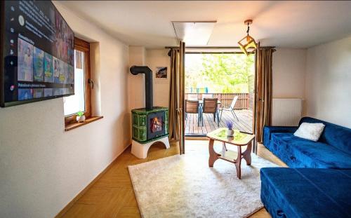 salon z niebieską kanapą i piecem opalanym drewnem w obiekcie Chatka M3 
