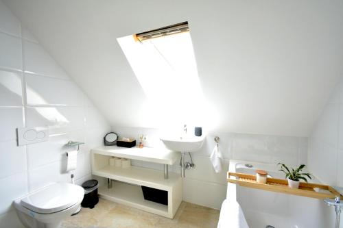 uma casa de banho branca com um lavatório e um WC em frigg flats I Industrial Style I Loft I Billard I em Landshut
