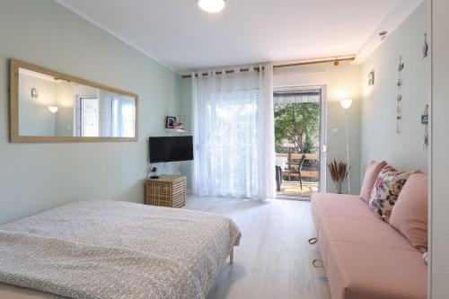a bedroom with a bed and a couch and a television at Ada in Rijeka