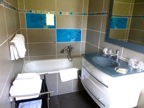 a bathroom with a sink and a bath tub at Hotel du Levant in Castellane