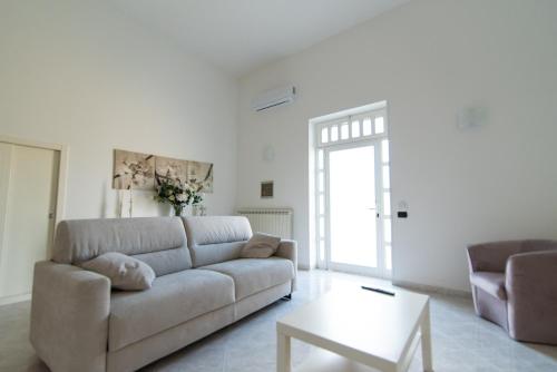 - un salon avec un canapé et une table dans l'établissement Dimora Azzurra, à Pezze di Greco