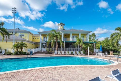 a house with a swimming pool in front of a house at Bahama Bay Resort & Spa - Deluxe Condo Apartments in Kissimmee