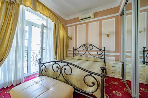 a bedroom with a wrought iron bed and a window at Gostiniy Dvor in Odesa