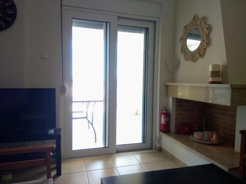 a living room with sliding doors and a fireplace at Sunrise guest house in Nydri