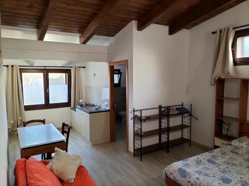 Cette chambre comprend un lit, une table et une cuisine. dans l'établissement Dimora Al Parco monolocale 2, à Domusnovas