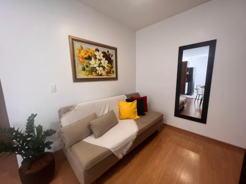 uma sala de estar com um sofá e um espelho em Apto ao lado do Shopping Caruaru próximo ao pátio unidade 302 em Caruaru