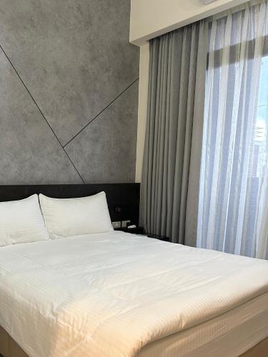 a bedroom with a white bed and a window at 北緯23點5度民宿-車位可預訂 in Hualien City