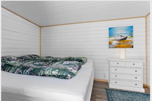 1 dormitorio con 1 cama y una pintura en la pared en Villa Bernhardina en Grebbestad
