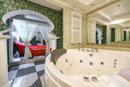 a bathroom with a tub and a large mirror at Gostiniy Dvor in Odesa