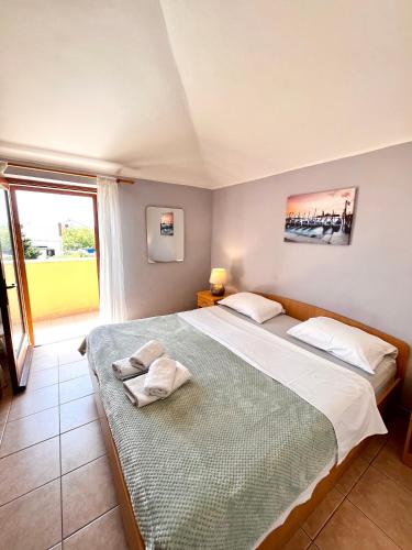 a bedroom with a large bed and a window at Anka in Nerezine