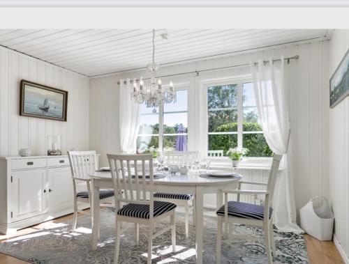a dining room with a white table and chairs at Villa Bernhardina in Grebbestad