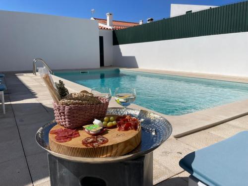 a tray of food on a table next to a swimming pool at MHouse lease Comporta Centro Villa 3 quartos in Comporta