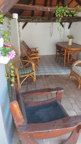 d'une terrasse avec des chaises, une table et une table. dans l'établissement Bela casa, à Hartbeespoort