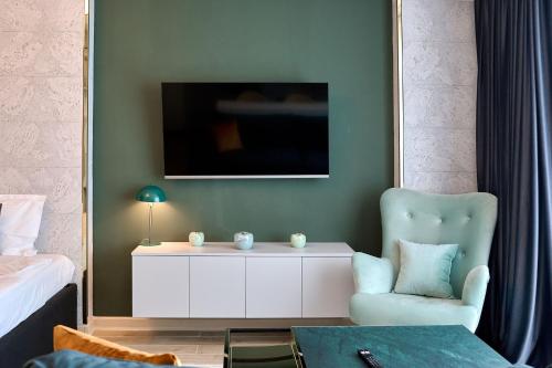 a bedroom with a bed and a chair and a table at Vogue Sunrise View in Infinity Pool & Spa Resort in Mamaia Sat/Năvodari
